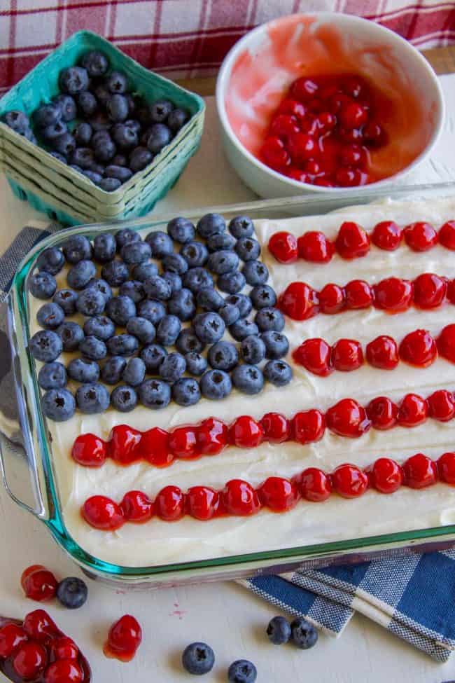Patriotic Flag Cake with Blueberries and Cherries from The Food Charlatan. This cherry-studded flag cake is the perfect patriotic dessert to bring for a Memorial day or Fourth of July barbecue! Blueberries and cherries on top are super easy and so festive! #patriotic #flag #blueberries #cherry #cherrypie #cake #cherrycake #creamcheese #frosting #flag #flagcake #american #fourthofjuly #4thofjuly #memorialday flag cake with blueberries and cherries