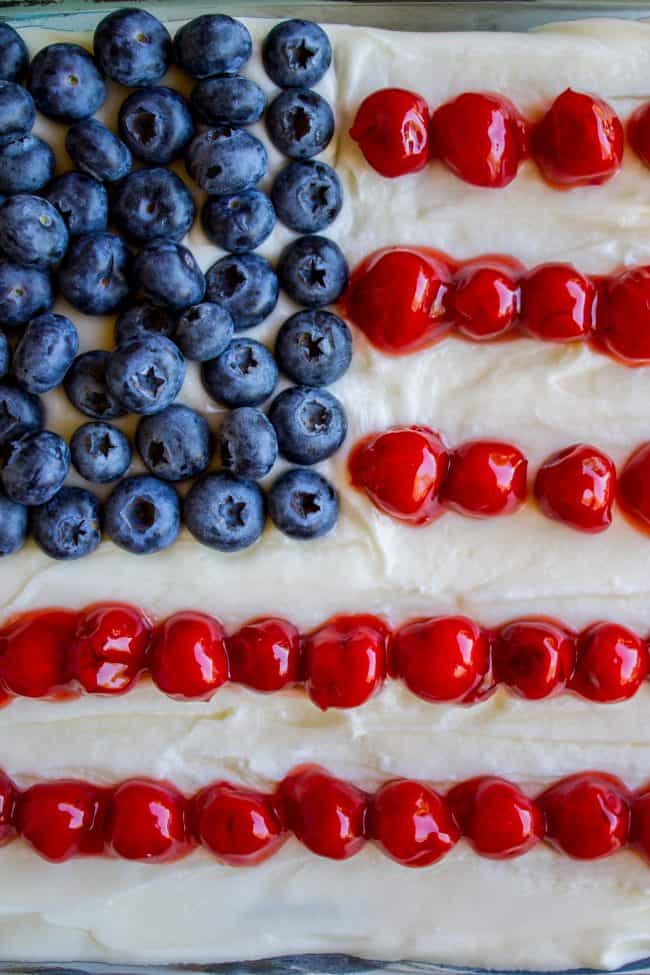Patriotic Flag Cake with Blueberries and Cherries from The Food Charlatan. This cherry-studded flag cake is the perfect patriotic dessert to bring for a Memorial day or Fourth of July barbecue! Blueberries and cherries on top are super easy and so festive! #patriotic #flag #blueberries #cherry #cherrypie #cake #cherrycake #creamcheese #frosting #flag #flagcake #american #fourthofjuly #4thofjuly #memorialday patriotic flag cake with cherries