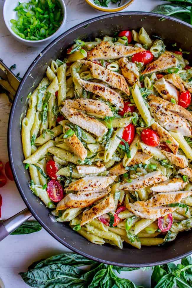30 Minute Pesto Penne with Chicken and Cherry Tomatoes from The Food Charlatan. This 30 Minute Pesto Penne Chicken is your new favorite last minute dinner! It's done so quick, you can even used canned chicken if you are really crunched for time. Swap the frozen green beans and cherry tomatoes for whatever veggies you have on hand! #pesto #pasta #cherrytomatoes #easydinner #fast #greenbeans #chicken #penne #basil #greenonions #mayonnaise #skillet #dinner #easydinner #healthy #healthydinner penne pesto chicken with cherry tomatoes in a skillet.