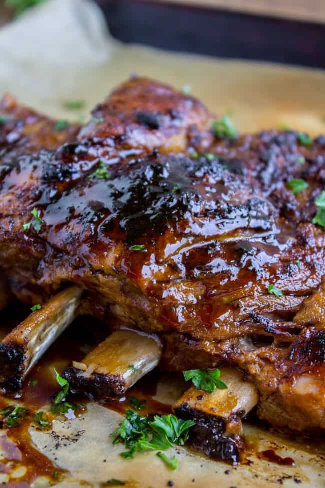 Honey Balsamic Slow Cooker Pork Ribs from The Food Charlatan. These slow cooker pork ribs are fall-off-the-bone delicious! The slow cooker makes them incredibly tender and moist, and the honey balsamic glaze just doesn't need an explanation. Does it?? They are SO easy to make! #ribs #porkribs #spareribs #honey #balsamic #balsamicvinegar #slowcooker #crockpot #glazed #pork a rack of pork topped with honey balsamic glaze