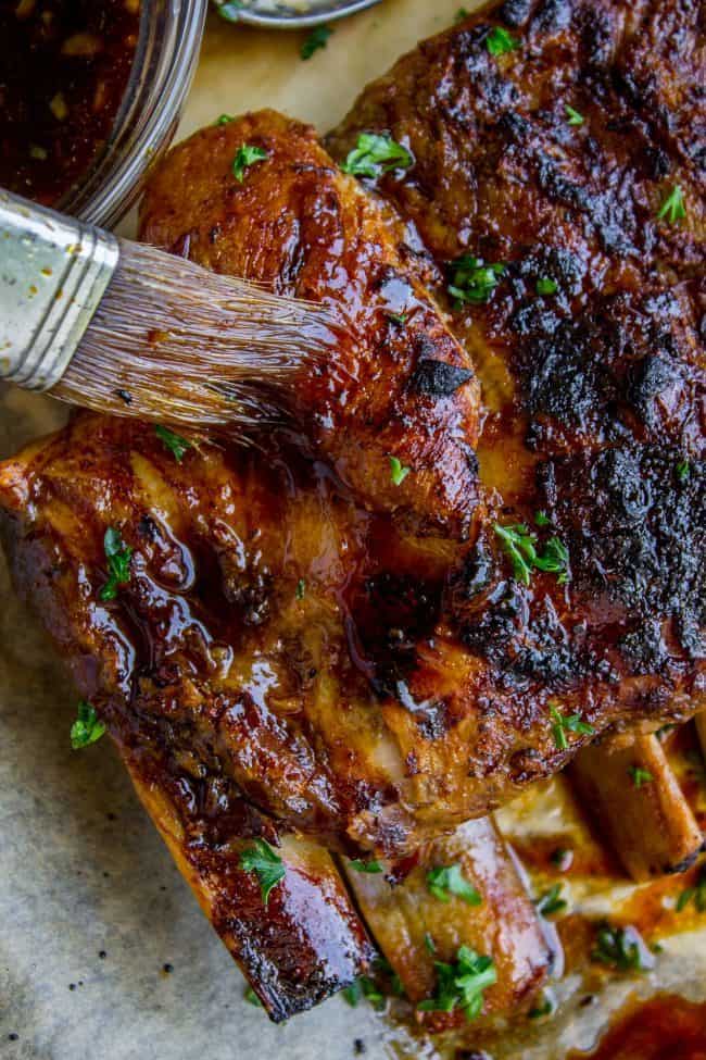 Honey Balsamic Slow Cooker Pork Ribs from The Food Charlatan. These slow cooker pork ribs are fall-off-the-bone delicious! The slow cooker makes them incredibly tender and moist, and the honey balsamic glaze just doesn't need an explanation. Does it?? They are SO easy to make! #ribs #porkribs #spareribs #honey #balsamic #balsamicvinegar #slowcooker #crockpot #glazed #pork slow cooker ribs being brushed with glaze