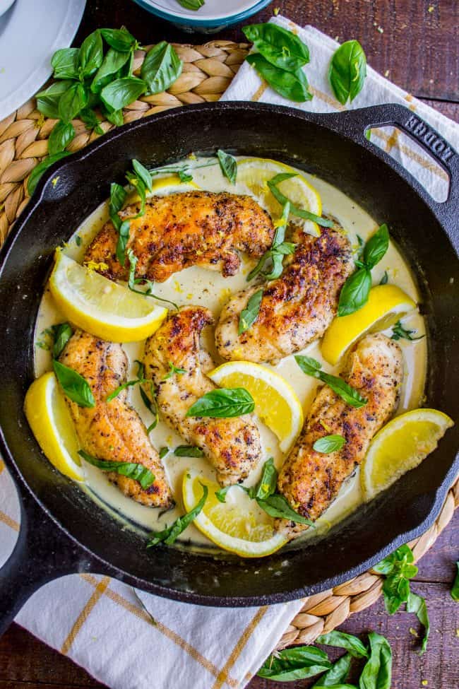 Pan-Seared Chicken in Lemon Basil Cream Sauce from The Food Charlatan. Here's an easy 30 minute dinner idea for you! Pan-seared Chicken in Lemon Basil Cream Sauce is super easy to throw together, and uses up some of that fresh garden basil. Chicken tenderloins are quick to cook on the stovetop, and the sauce has such bright lemony flavor! #chicken #lemon #lemonchicken #basil #summer #panseared #easy #fast #recipe #creamy #pansauce #30minute creamy lemon chicken with fresh basil in a cast iron skillet.