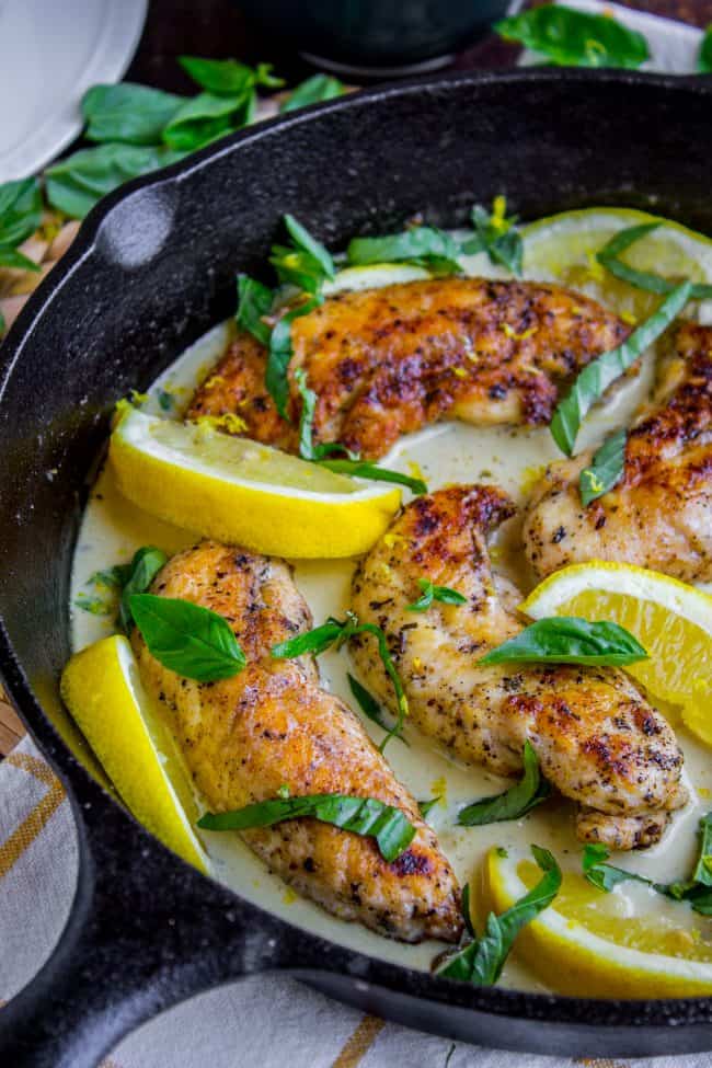Pan-Seared Chicken in Lemon Basil Cream Sauce from The Food Charlatan. Here's an easy 30 minute dinner idea for you! Pan-seared Chicken in Lemon Basil Cream Sauce is super easy to throw together, and uses up some of that fresh garden basil. Chicken tenderloins are quick to cook on the stovetop, and the sauce has such bright lemony flavor! #chicken #lemon #lemonchicken #basil #summer #panseared #easy #fast #recipe #creamy #pansauce #30minute lemon basil cream sauce surrounding chicken tenderloins in a cast iron skillet.