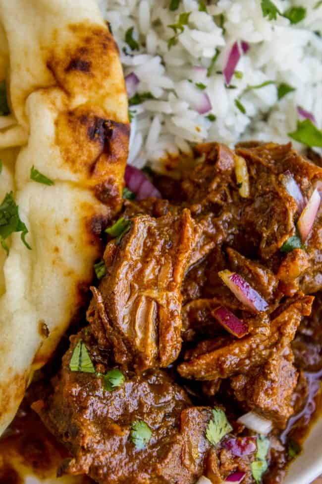 Slow Cooker Beef Curry from The Food Charlatan. This slow cooker beef curry could not be easier! Thick chunks of slow-cooked, tender beef, in a rich and thick curry sauce that is just waiting to be scooped up with some naan. #curry #beef #beefcurry #indian #indianfood #yellow #rice #naan #cilantro #tender #crockpot #slowcooker slow cooker beef curry with rice and naan.