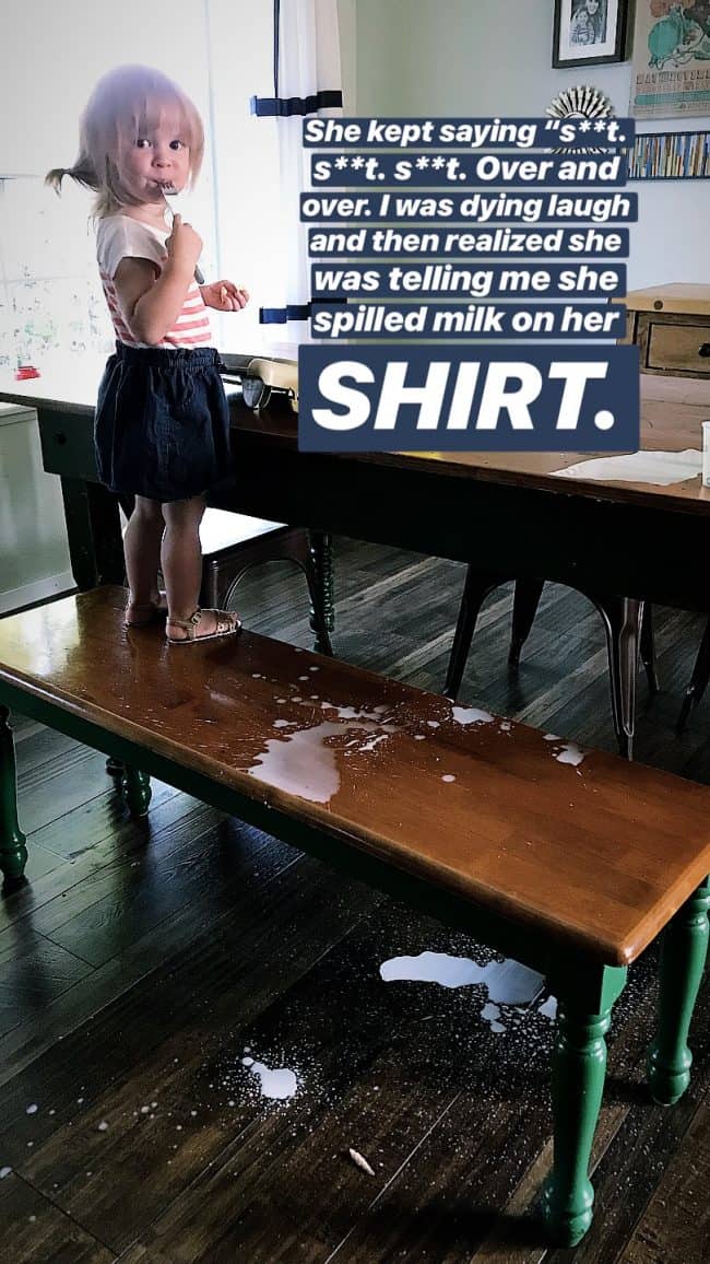 cute little girl at a table with spilled milk.