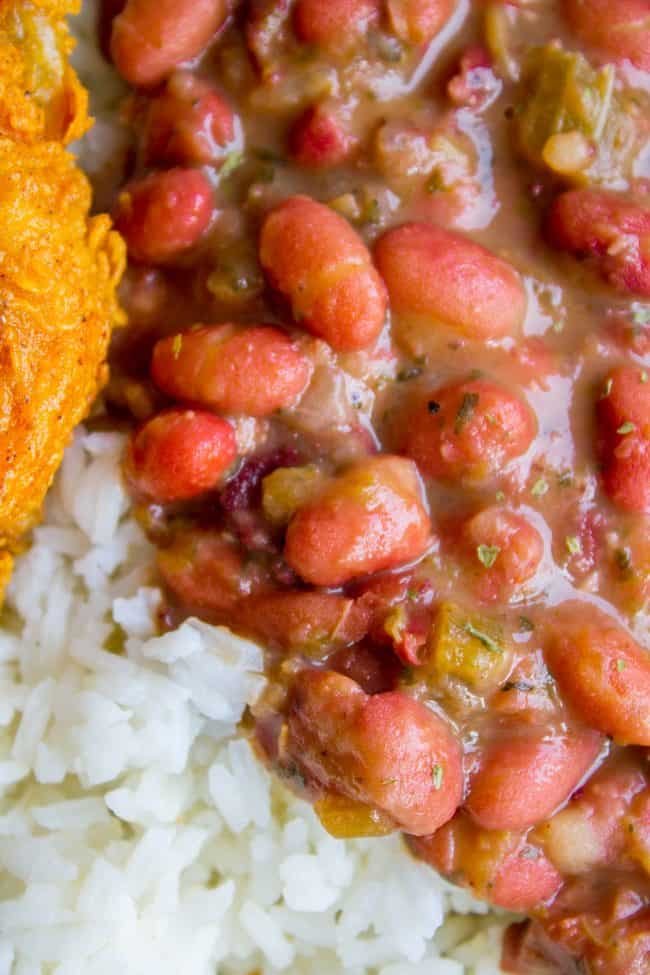 Red Beans and Rice (Better Than Popeye's!) from The Food Charlatan. Have you ever had traditional Red Beans and Rice? It's a southern staple! I tried Popeye's Red Beans and Rice for the first time a while back, but these beans are even better. They are so creamy and flavorful, with the perfect smoky Cajun spice! #redbeansandrice #riceandbeans #beans #rice #ham #hambone #smokey #traditional #southern #cajun #neworleans #popeyes #recipe #easy #stovetop #authentic #withham #Louisiana #best #creamy red beans and rice with fried chicken.
