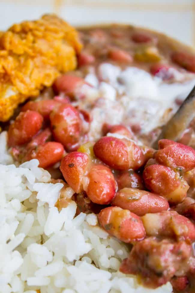 Red Beans and Rice (Better Than Popeye's!) from The Food Charlatan. Have you ever had traditional Red Beans and Rice? It's a southern staple! I tried Popeye's Red Beans and Rice for the first time a while back, but these beans are even better. They are so creamy and flavorful, with the perfect smoky Cajun spice! #redbeansandrice #riceandbeans #beans #rice #ham #hambone #smokey #traditional #southern #cajun #neworleans #popeyes #recipe #easy #stovetop #authentic #withham #Louisiana #best #creamy red beans and rice with fried chicken.