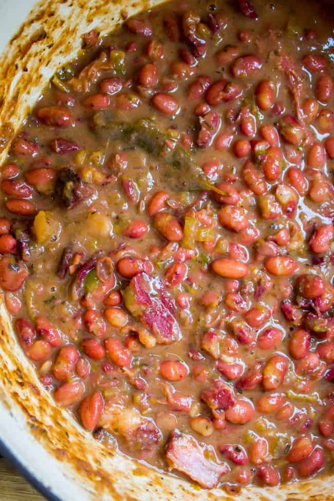 Red Beans and Rice (Better Than Popeye's!) from The Food Charlatan. Have you ever had traditional Red Beans and Rice? It's a southern staple! I tried Popeye's Red Beans and Rice for the first time a while back, but these beans are even better. They are so creamy and flavorful, with the perfect smoky Cajun spice! #redbeansandrice #riceandbeans #beans #rice #ham #hambone #smokey #traditional #southern #cajun #neworleans #popeyes #recipe #easy #stovetop #authentic #withham #Louisiana #best #creamy a big pot of red beans.