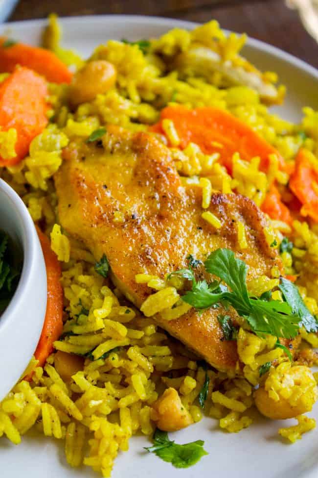 Chicken Biryani (30 Minute Indian Chicken & Rice) from The Food Charlatan. This stove top Chicken Biryani is a delicious 30 minute dinner! You could also call it Indian Chicken and Rice. It's so easy to make and is a healthy weeknight dinner that everyone will love! #chicken #chickendinner #easy #recipe #indian #indianfood #30minutes #dinner #healthy #carrots #onion #cilantro #cashew #stovetop #oneskillet #onepot #rice #basmati #spices #curry #vegetable #skillet chicken biryani on a white plate.