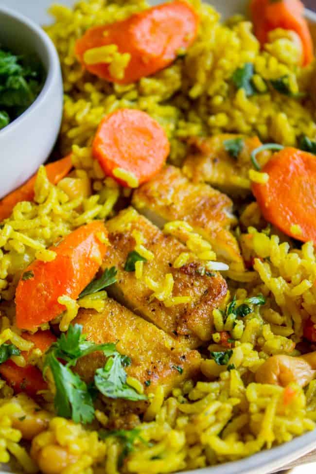 Chicken Biryani (30 Minute Indian Chicken & Rice) from The Food Charlatan. This stove top Chicken Biryani is a delicious 30 minute dinner! You could also call it Indian Chicken and Rice. It's so easy to make and is a healthy weeknight dinner that everyone will love! #chicken #chickendinner #easy #recipe #indian #indianfood #30minutes #dinner #healthy #carrots #onion #cilantro #cashew #stovetop #oneskillet #onepot #rice #basmati #spices #curry #vegetable #skillet Indian chicken curry on a plate.