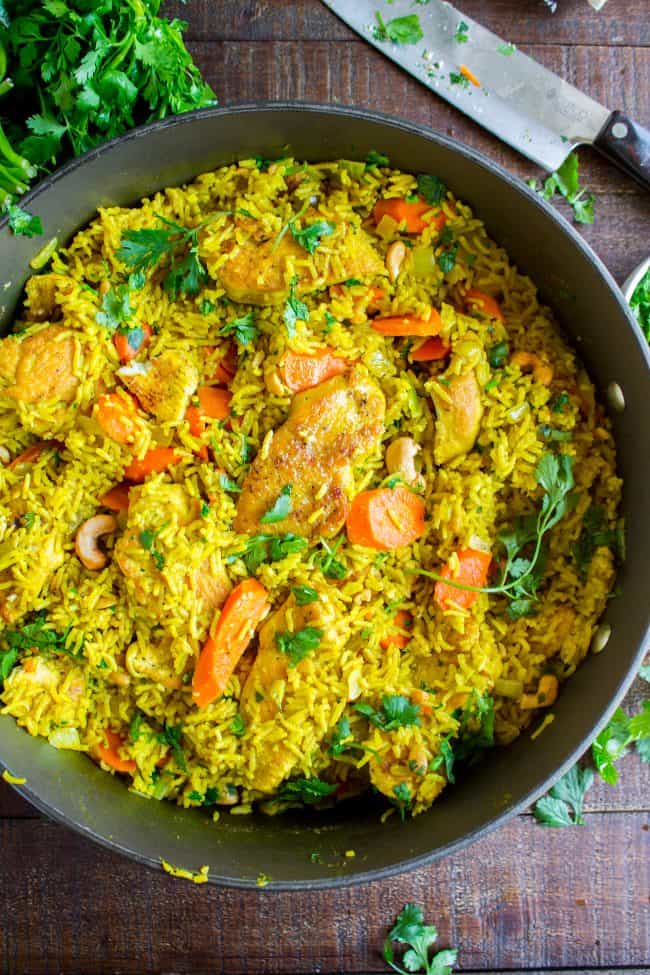 Chicken Biryani (30 Minute Indian Chicken & Rice) from The Food Charlatan. This stove top Chicken Biryani is a delicious 30 minute dinner! You could also call it Indian Chicken and Rice. It's so easy to make and is a healthy weeknight dinner that everyone will love! #chicken #chickendinner #easy #recipe #indian #indianfood #30minutes #dinner #healthy #carrots #onion #cilantro #cashew #stovetop #oneskillet #onepot #rice #basmati #spices #curry #vegetable #skillet chicken biryani in a skillet.