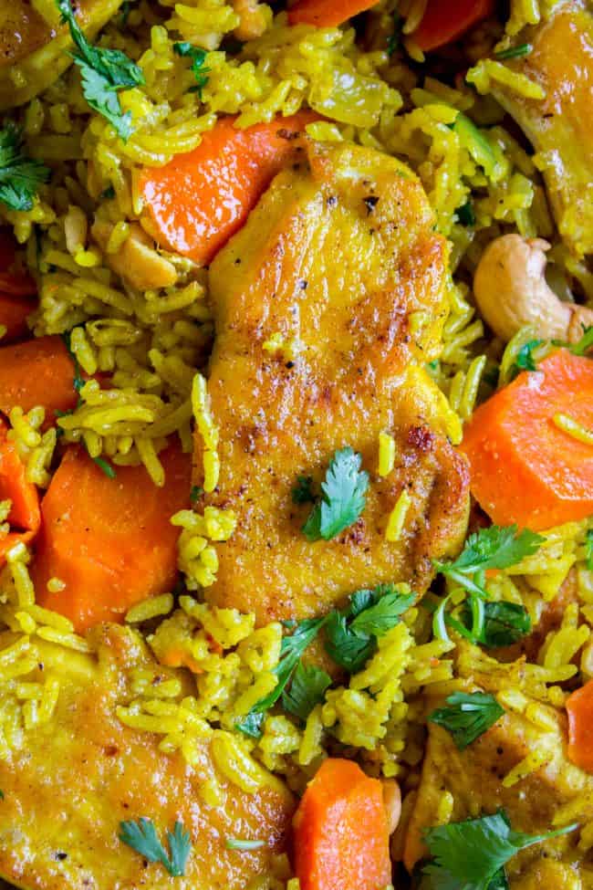 Chicken Biryani (30 Minute Indian Chicken & Rice) from The Food Charlatan. This stove top Chicken Biryani is a delicious 30 minute dinner! You could also call it Indian Chicken and Rice. It's so easy to make and is a healthy weeknight dinner that everyone will love! #chicken #chickendinner #easy #recipe #indian #indianfood #30minutes #dinner #healthy #carrots #onion #cilantro #cashew #stovetop #oneskillet #onepot #rice #basmati #spices #curry #vegetable #skillet chicken biryani shot from up close.