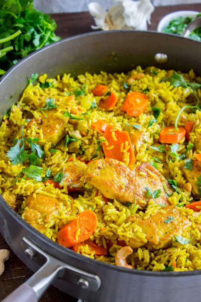 Chicken Biryani (30 Minute Indian Chicken & Rice) from The Food Charlatan. This stove top Chicken Biryani is a delicious 30 minute dinner! You could also call it Indian Chicken and Rice. It's so easy to make and is a healthy weeknight dinner that everyone will love! #chicken #chickendinner #easy #recipe #indian #indianfood #30minutes #dinner #healthy #carrots #onion #cilantro #cashew #stovetop #oneskillet #onepot #rice #basmati #spices #curry #vegetable #skillet Chicken biryani in a skillet.