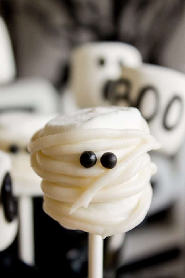 Halloween Marshmallow Pops from The Food Charlatan. Marshmallow pops are about 100x easier to make than cake pops, and so festive for parties! Skip the baking and get to the fun dipping part. Frankenstein, ghosts, mummies, oh my! Your kids will love this easy Halloween project! #halloween #marshmallow #pops #cakepops #marshmallowpops #frankenstein #monster #boo #party #ghost #easy #dessert #kids #howtomake #dipped #centerpiece # fall #diy how to make marshmallow pops