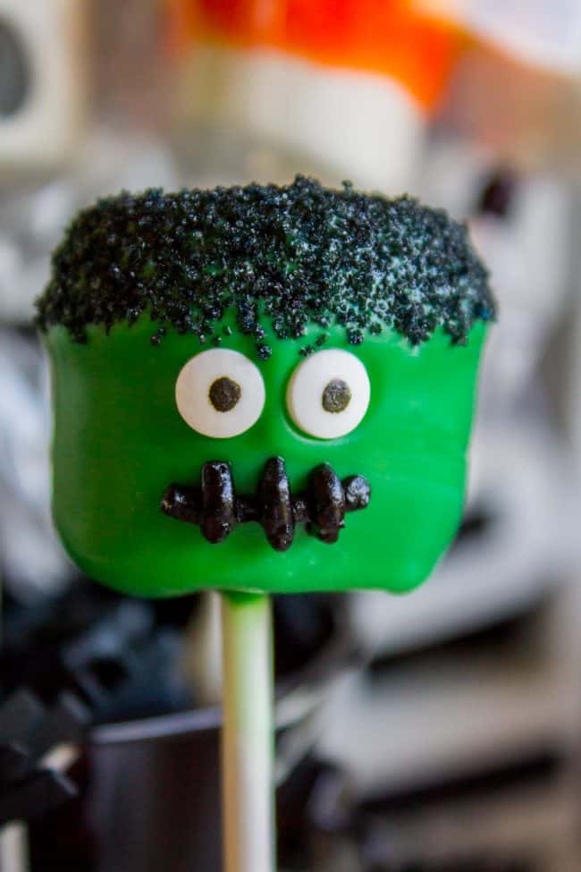 Halloween Marshmallow Pops from The Food Charlatan. Marshmallow pops are about 100x easier to make than cake pops, and so festive for parties! Skip the baking and get to the fun dipping part. Frankenstein, ghosts, mummies, oh my! Your kids will love this easy Halloween project! #halloween #marshmallow #pops #cakepops #marshmallowpops #frankenstein #monster #boo #party #ghost #easy #dessert #kids #howtomake #dipped #centerpiece # fall #diy how to make marshmallow pops