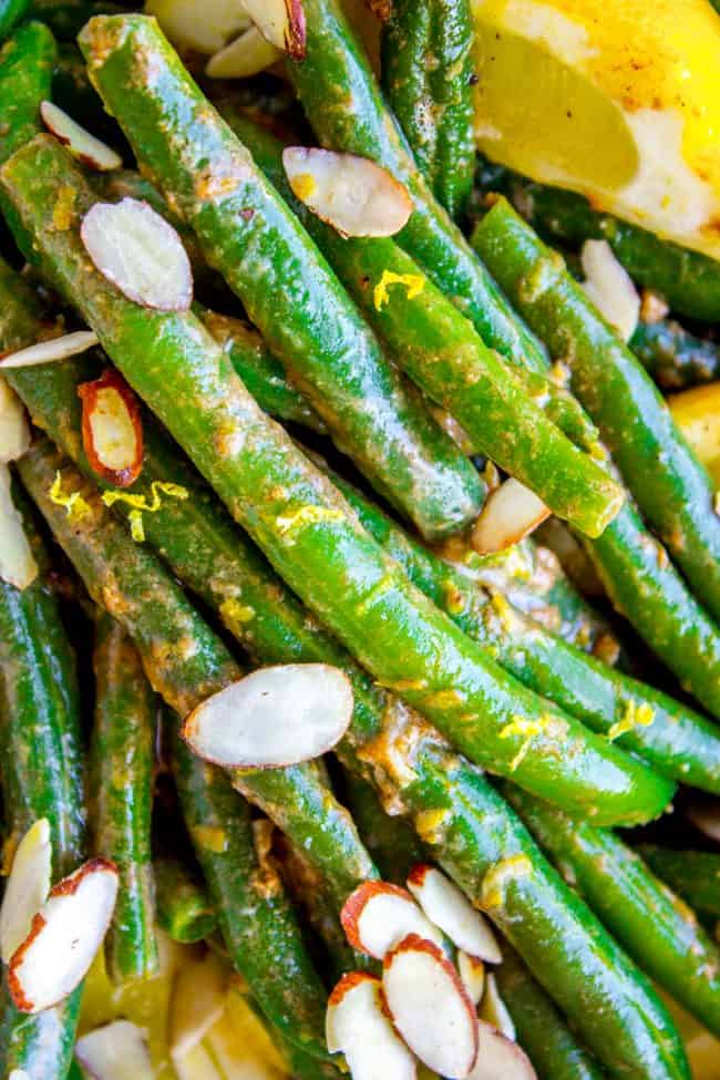 Lemon Dijon Green Beans Almondine from The Food Charlatan. Lemon Dijon Green Beans Almondine is super easy and has tons of flavor! How can you go wrong with butter (and maybe browning it a little?) and lemon and Dijon? You can even make this ahead of time if you plan to serve it for Thanksgiving dinner. #greenbean #almondine #almond #beans #lemon #dijon #mustard #garlic #brownedbutter #butter #sidedish #Thanksgiving #sauteed #fresh #healthy #easy #recipes #withalmonds green beans with lemon zest and almonds.