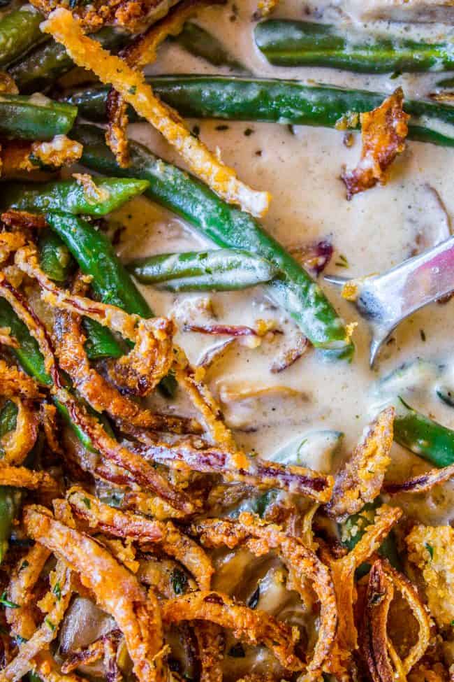 Homemade Green Bean Casserole Recipe from The Food Charlatan. Not your mama's Green Bean Casserole recipe! Let's kick that can of soup out to the curb because the homemade version is LEGIT you guys. Big, bright green beans in a creamy mushroom sauce, topped with crispy fried onions. Thanksgiving doesn't get any better than this! #greenbeans #casserole #frenchs #fromscratch #homemade #thanksgiving #sidedish #easy #fresh #recipe #classic #best #withcheese #foracrowd #makeahead #simple #classic #creamy homemade green bean casserole with crispy fried onions.