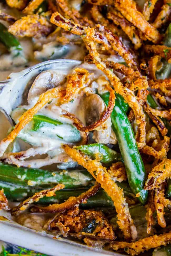 Homemade Green Bean Casserole Recipe from The Food Charlatan. Not your mama's Green Bean Casserole recipe! Let's kick that can of soup out to the curb because the homemade version is LEGIT you guys. Big, bright green beans in a creamy mushroom sauce, topped with crispy fried onions. Thanksgiving doesn't get any better than this! #greenbeans #casserole #frenchs #fromscratch #homemade #thanksgiving #sidedish #easy #fresh #recipe #classic #best #withcheese #foracrowd #makeahead #simple #classic #creamy green bean casserole with creamy homemade sauce and crispy fried onions.