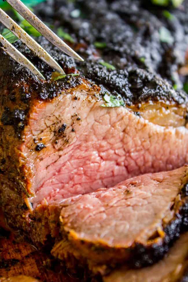 tri tip steak with one slice cut out, pierced by a fork.