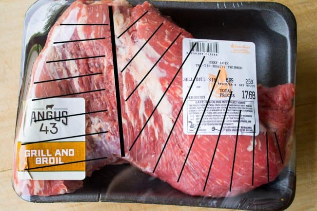 raw tri tip with black lines showing the grain of the steak.