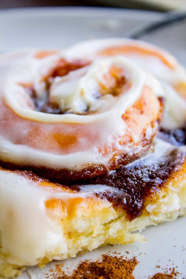 The FLUFFIEST Homemade Cinnamon Rolls of Your Life (Can Make Overnight) from The Food Charlatan. If you haven't made cinnamon rolls with a simple sweet dough (brioche style) instead of regular bread dough, you are totally missing out. These are the FLUFFIEST homemade cinnamon rolls of your life! They are very easy, and you can make them overnight! #cinnamon #cinnamonrolls #creamcheese #frosting #homemade #fluffy #gooey #easy #overnight #cinnabon #recipe #best #fromscratch #icing #makeahead homemade cinnamon rolls with frosting on top.