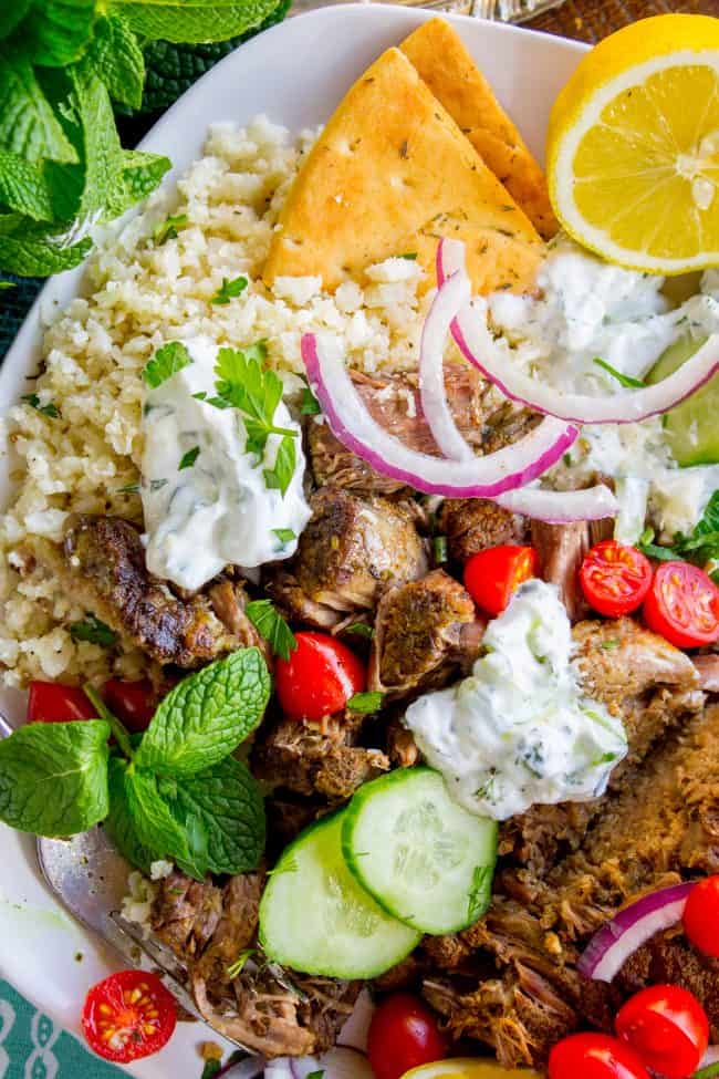 Gyro Style Shredded Beef (Instant Pot or Crock Pot) from The Food Charlatan. All the gyro flavors you love, shredded beef style! This is a super delicious and HEALTHY option for dinner. Make it in the Instant Pot or the Crock Pot! Don't forget to pair it with Tzatziki Sauce (<<it's killer) and Cauliflower Rice. #gyro #gyromeat #beef #shreddedbeef #slowcooker #crockpot #pressurecooker #instantpot #healthy #paleo #whole30 #Greek #pita #rice #tzatziki #sauce #easy shredded gyro beef with cauliflower rice, tzatziki sauce, toasted pita bread, fresh veggies, and herbs.