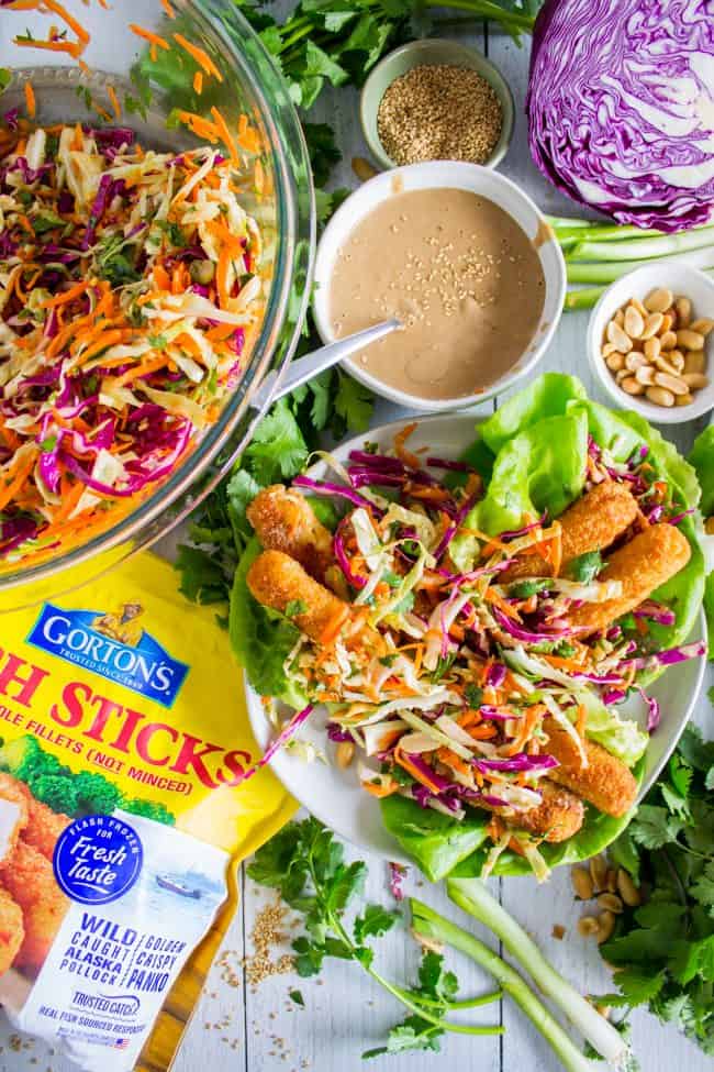 Thai Lettuce Wraps with Crispy Fish and Peanut Sauce from The Food Charlatan. These are a fabulous way to start off your January! Supple butter lettuce wrapped around crispy baked fish, topped with a gingery homemade Asian slaw. Drizzle with sweet and spicy Thai Peanut Sauce and you have an easy and healthy Asian-inspired weeknight dinner! #healthy #fish #crispy #cabbage #slaw #asian #Thai #peanutsauce #easy #sauce #lowcarb #lunch #simple #butterlettuce #greenonion #carrot #purplecabbage Thai fish tacos.