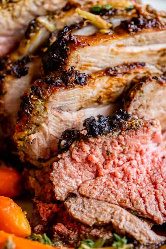 Roast Leg of Lamb with Blackened Honey Dijon Crust from The Food Charlatan. #ad #OhMaille #MyMaille #IDidItMailleWay Roast leg of lamb makes an unforgettable main dish for your Easter celebration! Roast lamb is so delicious, moist, and tender when it is done right. The secret is to turn the oven to 500 degrees to get that blackened honey dijon crust made with Maille® Honey Dijon, then lower it to get the most tender, juicy roast lamb you've ever had. #Walmart #leg #recipes #dinner #easter #lamb roast leg of lamb sliced.