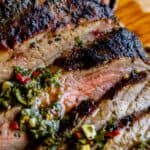 close up of tender flank steak broiled on top with herbs