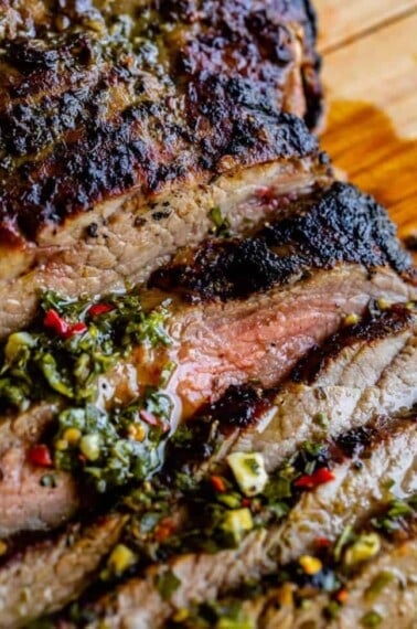 close up of tender flank steak broiled on top with herbs