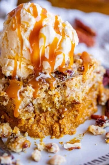 slice of pumpkin dump cake with ice cream and caramel sauce on top