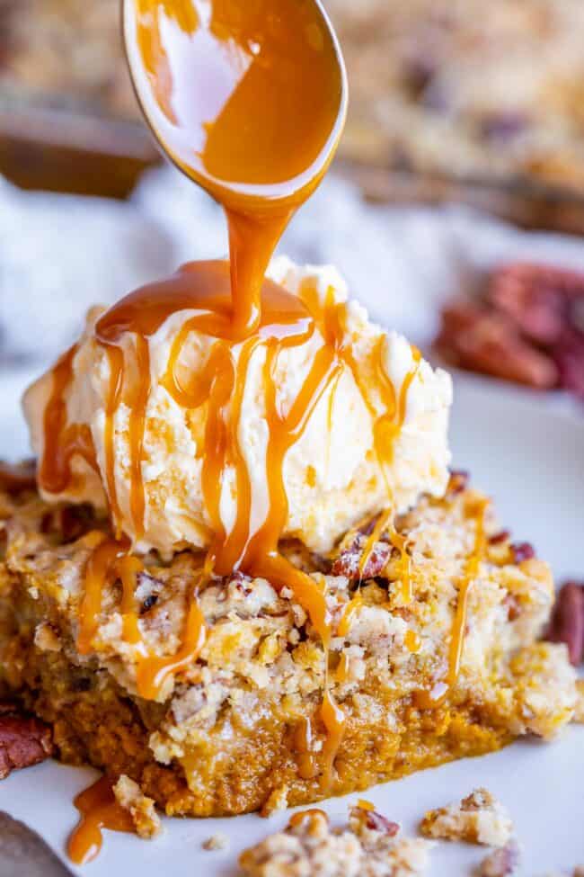 ice cream on a slice of pumpkin pecan cake drizzled with caramel sauce.