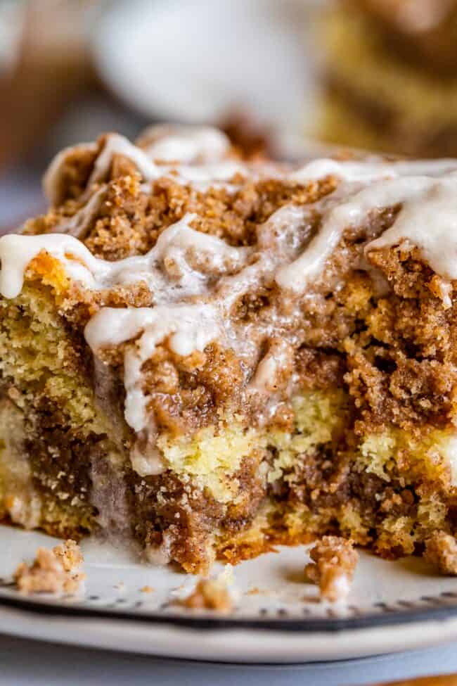 Sour Cream Coffee Cake, with a Ridiculous Amount of Streusel from The Food Charlatan. This is my FAVORITE recipe for Sour Cream Coffee Cake! My main complaint with Coffee Cake is that there is usually too much cake, not enough streusel. This recipe gives you the max amount of streusel without ruining the light fluffiness of the cake! A vanilla drizzle finishes it off! #coffeecake #sourcream #icing #frosting #drizzle #easy #recipes #cinnamon #streusel #sourcream #crumb #crumble #moist #breakfast Close up of slice of cinnamon streusel coffee cake.