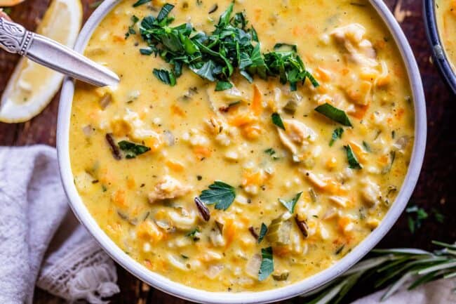 Creamy Turkey Wild Rice Soup recipe from The Food Charlatan! Use your leftover turkey and herbs from Thanksgiving to make a satisfying and healthy soup that is just what you need after all the carb loading you did on Thursday. (I know you.) The hint of lemon and the shredded carrots make this soup really unique and flavorful! #turkey #thanksgiving #christmas #broth #stock #carrots #creamy #crockpot #slowcooker #recipes #leftover #easy #healthy #homemade #carrots #lemon #leftovers #stovetop turkey and wild rice soup in a bowl