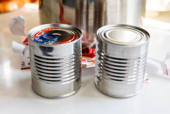 Preparing cans without labels to make dulce de leche.