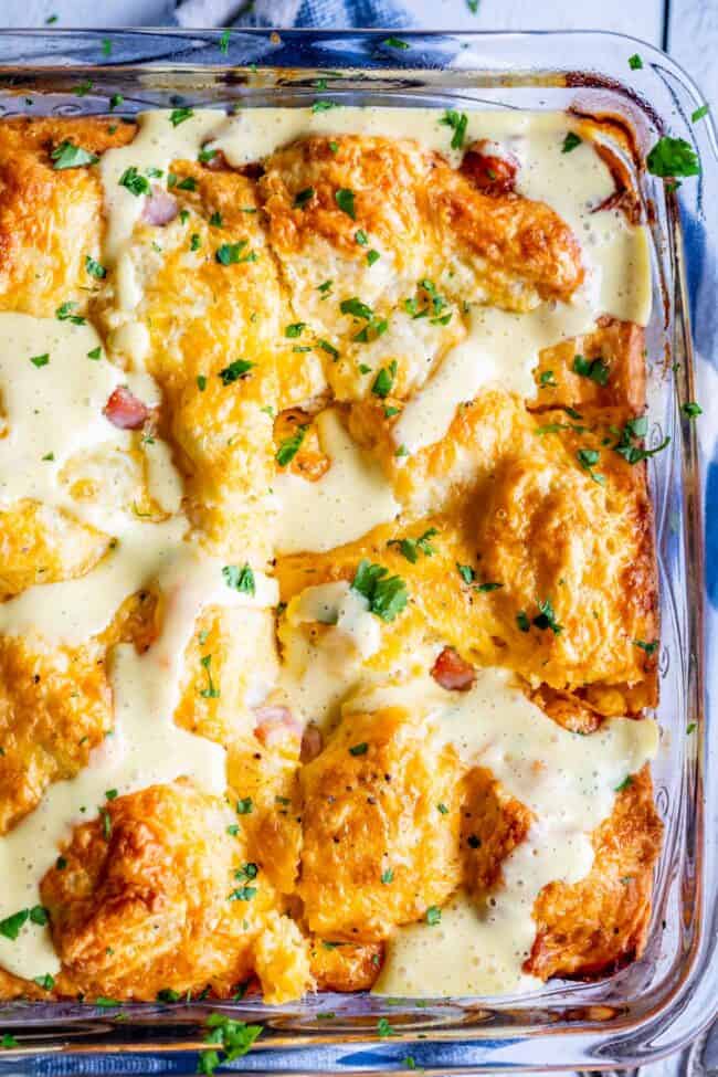 Cheesy Ham and Egg Breakfast Casserole with Biscuits from The Food Charlatan. This crowd-pleasing casserole is my new favorite! Use store bought or homemade biscuits to make a moist and delicious brunch. Top it all off with Hollandaise Sauce for an amazing holiday breakfast! #breakfast #brunch #ham #bacon #sausage #easy #recipe #holidays #Thanksgiving #Christmas #makeahead #withbiscuits #overnight #recipes #foracrowd #best #nightbefore #simple #quick #forlargegroups #Pillsbury #freezer #savory biscuit breakfast casserole with ham and hollandaise sauce.