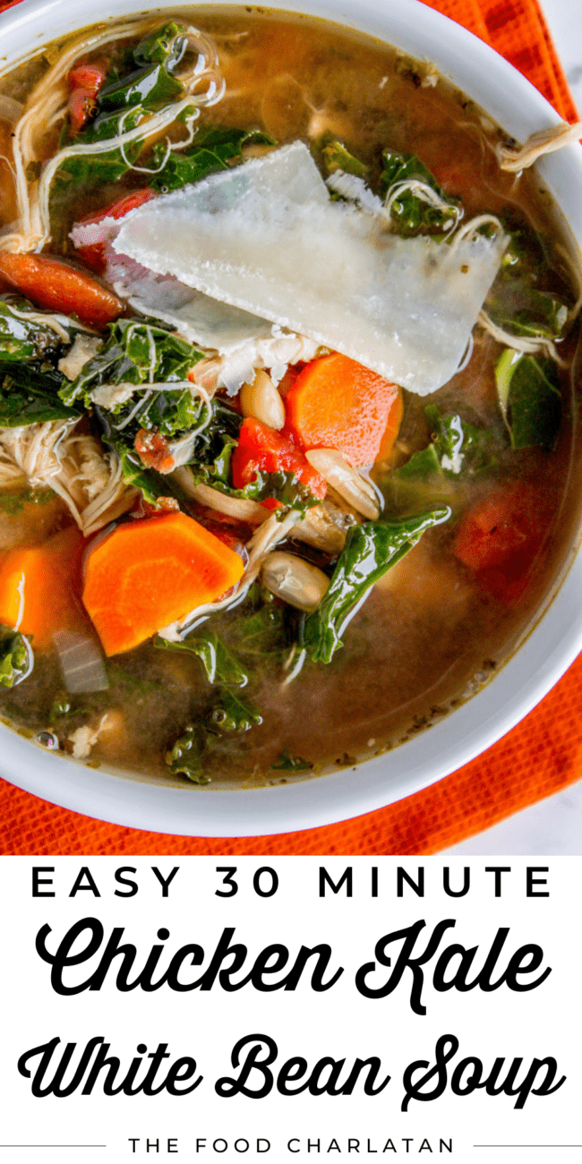 a bowl of chicken, kale, and white bean soup with parmesan shavings.