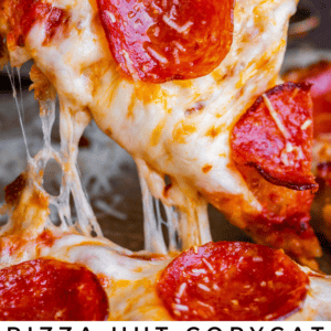 A hand lifts a cheesy, pepperoni-topped slice of cast iron pan pizza with melted mozzarella stretching from the pan. Text on the image reads: Pizza Hut Copycat Cast Iron Pan Pizza - The Food Charlatan. Enjoy this mouthwatering cast iron delight.