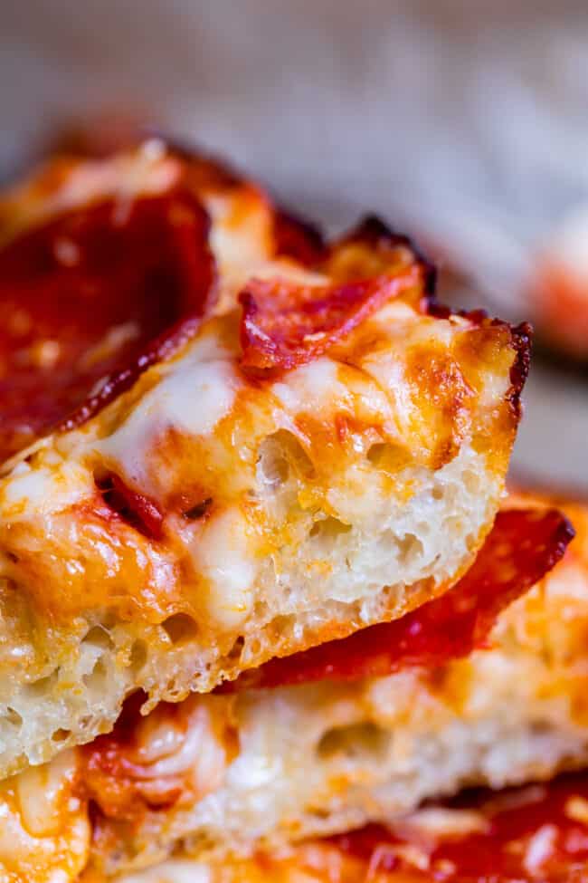 slices of homemade pan pizza stacked up.
