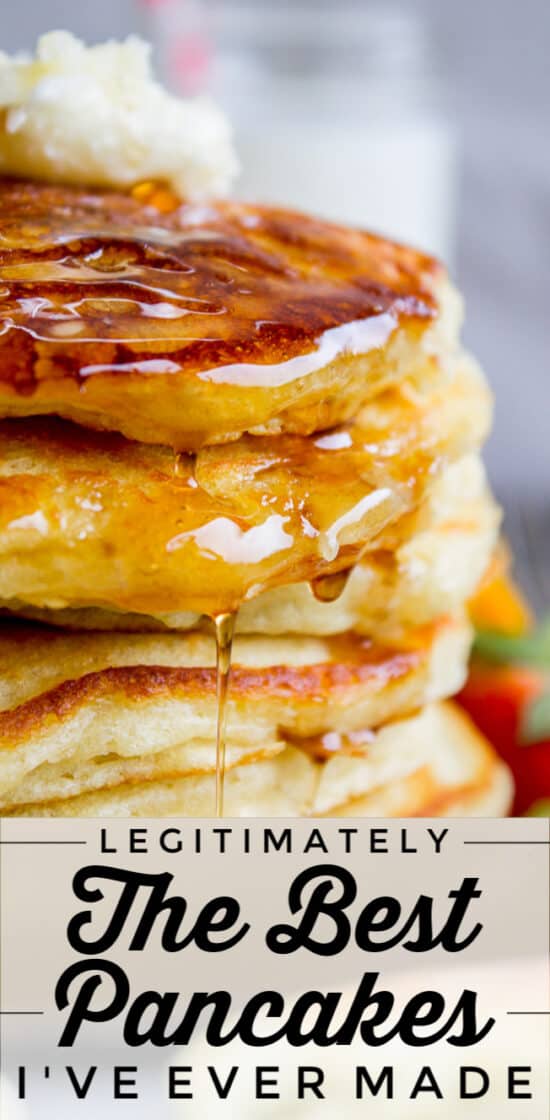 pin of stacked pancakes with bite sliced out and strawberries