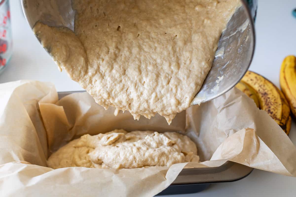 pouring banana bread batter into pan
