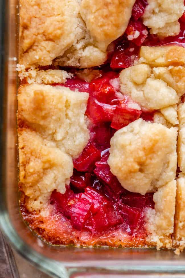 Rhubarb Shortbread Bars from The Food Charlatan. Rhubarb Shortbread Bars are a dream come true! A thick and buttery shortbread crust, topped with a layer of simple rhubarb filling, and topped with even more glorious shortbread. There is a secret ingredient in this recipe that makes these rhubarb bars bright ruby red, and it's not food coloring. It works like a charm! #easy #recipe #rhubarb #shortbread #butter #bars #dessert #withoutstrawberry #recipe #shortbreadcrust #lemon #best #pie rhubarb shortbread bars, pictured from above