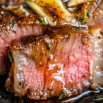 rib eye steak grilled or pan seared, close up of a medium rare slice leaking juices.
