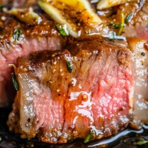 rib eye steak grilled or pan seared, close up of a medium rare slice leaking juices.