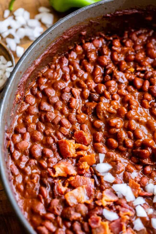 Santa Maria Pinquito Beans from The Food Charlatan. These Santa Maria style Pinquito Beans are the perfect summer barbecue side dish! Originally created in Santa Maria, California to be served alongside Grilled Tri Tip, these beans are smokey and sweet with the perfect blend of spices. Eat them with tri tip or serve alongside whatever else you're barbecuing this summer! #easy #recipe #bbq #barbecue #beans #bakedbeans #santamaria #tritip #sidedish #bacon #pinquito #creamy #summer #onion #anaheim santa maria pinquito beans in a pan.