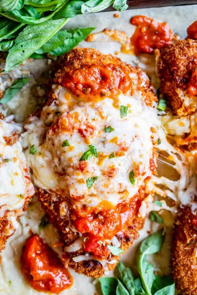 crispy chicken parmesan on a pan with cheese stretch; shot from overhead.