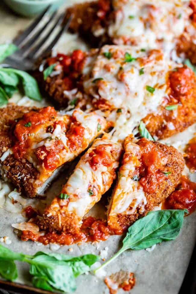 easy chicken parm, cut into strips with a fork in the background.