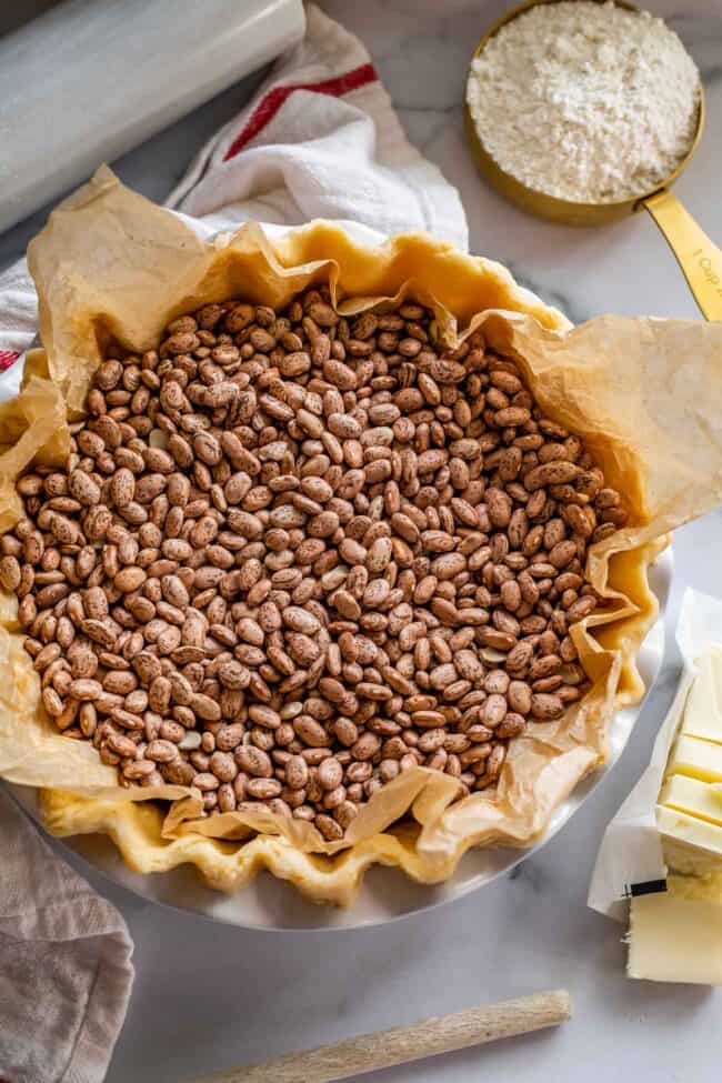 raw pie dough in a pan with beans as weights.