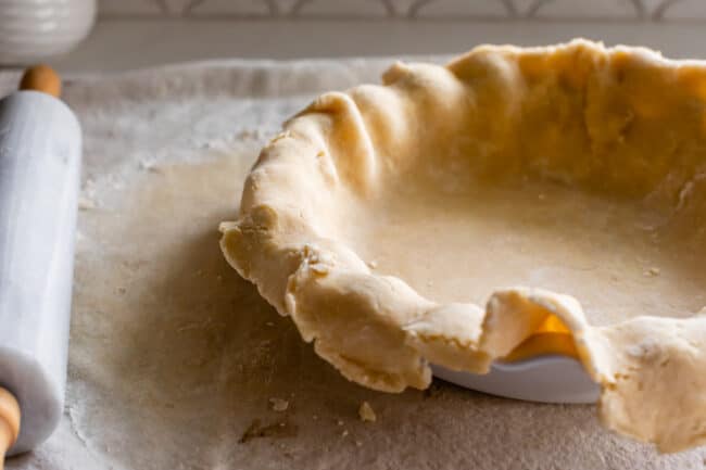 raw pie dough rolled out in a pie pan, ready to blind bake.