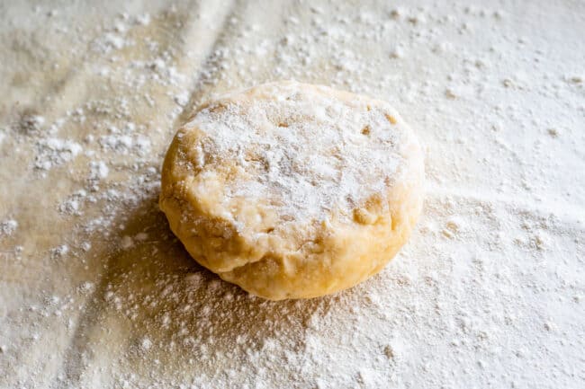 disc of chilled pie dough sprinkled with flour ready to be rolled out.